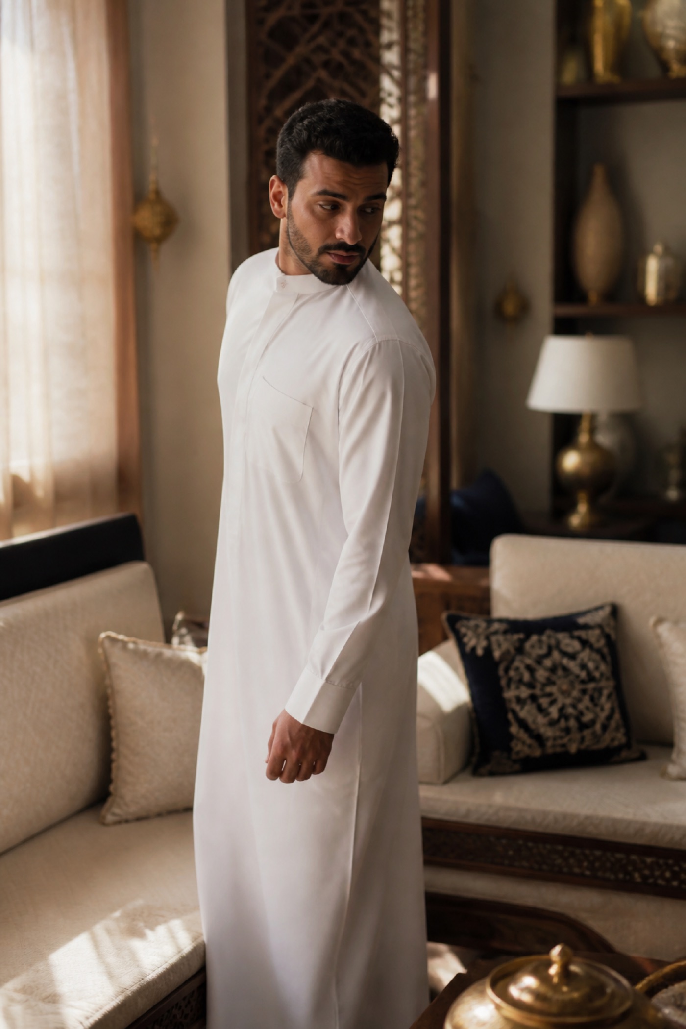 رجل بثوب أبيض يقف من المجلس ويلتفت نحو ظهره